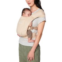 Esta mochila portabebé da marca Ergobaby é de cor creme. É ideal para transportar o bebé de forma segura e confortável, pois possui alças acolchoadas e malha respirável.